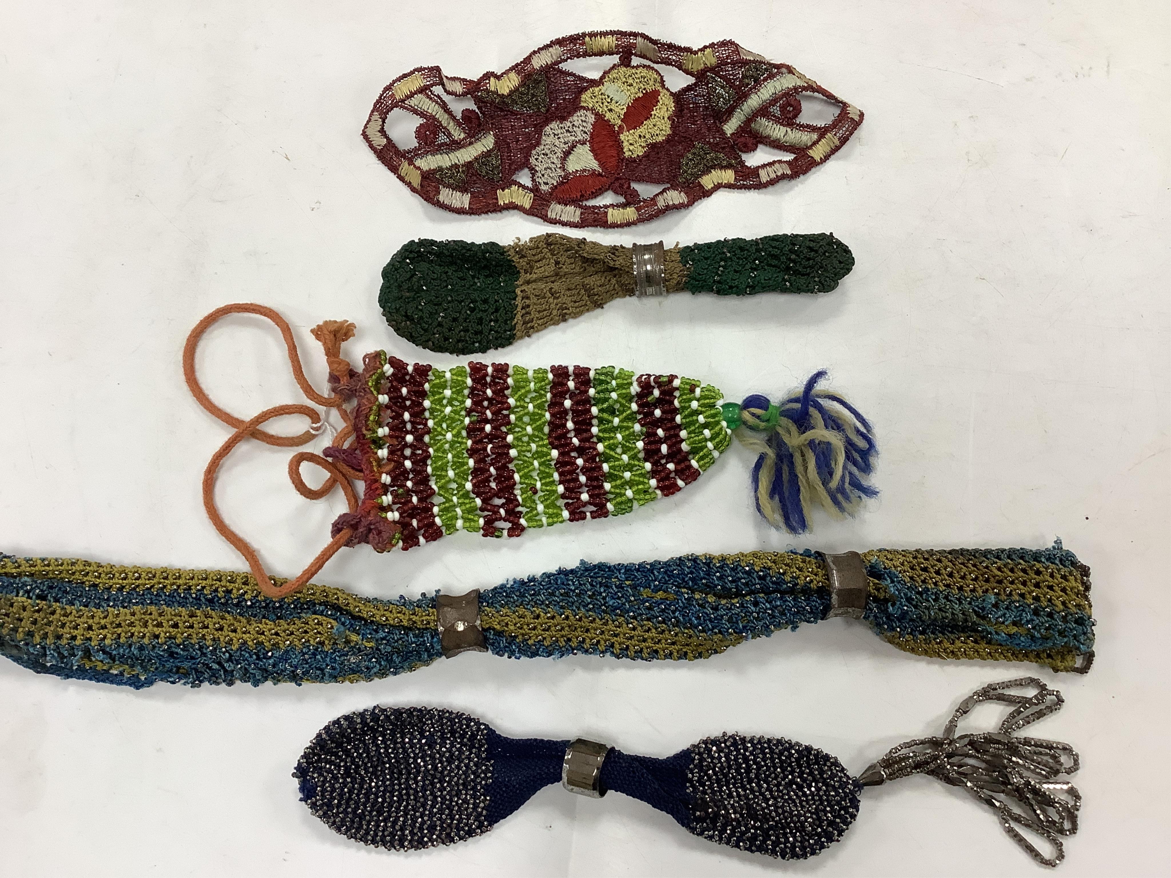 Three early 19th century knitted and cut steel Miser purses and a beadwork pouch purse and appliqué embroidery, longest 25cm. Condition - two have slight rust.
